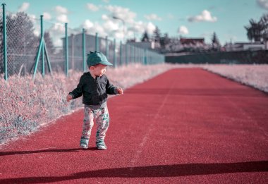 Polonya 'da atletizm pistinde koşan küçük bir çocuk.