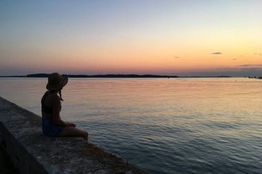 Sahilde, güzel gün batımında mutlu insanların siluetleri..