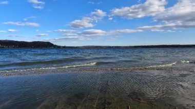 Rüzgarlı bir günde gölün kenarında yürüyorum.