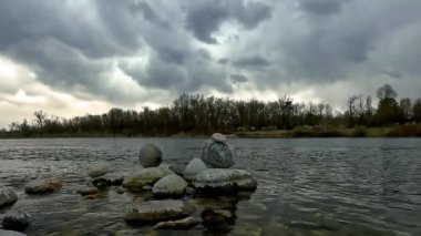 Gök gürültüsünden önce nehir kıyısında taş dengesi.