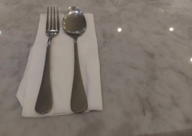 Bir çift kaşık ve çatal mermer bir masada beyaz bir doku üzerinde. Sekssel odaklanma. İzole edilmiş arkaplan