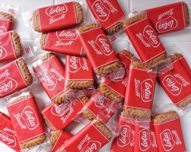 Lotus biscoff bisküvileri. Virüslü atıştırmalıklar. Tadı çok güzel. Genellikle tatlılarda süs olarak kullanılır. Karamelli ve çıtır çıtır. Beyazlar içinde izole edilmiş bir arka plan. Üst Manzara. Flatlay fotoğrafçılık. Neşeli bir ruh hali