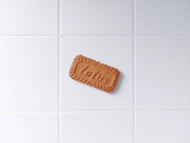 Lotus biscoff bisküvileri. Virüslü atıştırmalıklar. Tadı çok güzel. Genellikle tatlılarda süs olarak kullanılır. Karamelli ve çıtır çıtır. Beyazlar içinde izole edilmiş bir arka plan. Üst Manzara. Flatlay fotoğrafçılık. Neşeli bir ruh hali