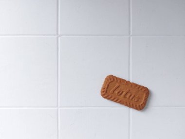 Lotus biscoff bisküvileri. Virüslü atıştırmalıklar. Tadı çok güzel. Genellikle tatlılarda süs olarak kullanılır. Karamelli ve çıtır çıtır. Beyazlar içinde izole edilmiş bir arka plan. Üst Manzara. Flatlay fotoğrafçılık. Neşeli bir ruh hali