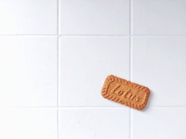 Lotus biscoff bisküvileri. Virüslü atıştırmalıklar. Tadı çok güzel. Genellikle tatlılarda süs olarak kullanılır. Karamelli ve çıtır çıtır. Beyazlar içinde izole edilmiş bir arka plan. Üst Manzara. Flatlay fotoğrafçılık. Neşeli bir ruh hali