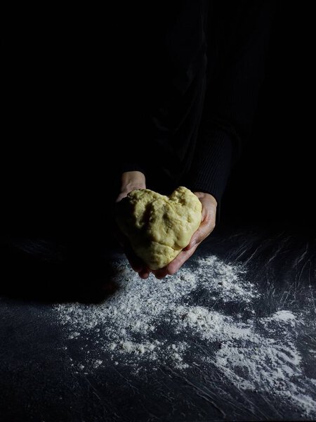 Женщины делают тесто из муки. Фотография выпечки. Темное настроение.