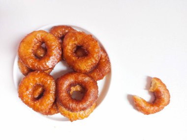 Yüzüklü pasta ya da Kue ali kabul ya da kue cincin. Sundan ya da Endonezya geleneksel tatlıları. Zevkli. Beyaz tabakta servis edilmiş. Beyazlar içinde izole edilmiş bir arka plan. Minimalist ve estetik gıda fotoğrafçılığı.