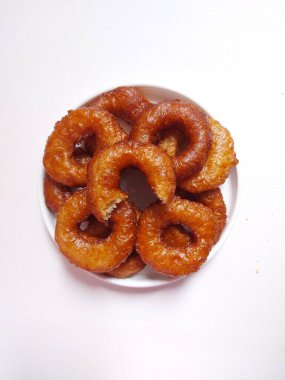 Yüzüklü pasta ya da Kue ali kabul ya da kue cincin. Sundan ya da Endonezya geleneksel tatlıları. Zevkli. Beyaz tabakta servis edilmiş. Beyazlar içinde izole edilmiş bir arka plan. Minimalist ve estetik gıda fotoğrafçılığı.