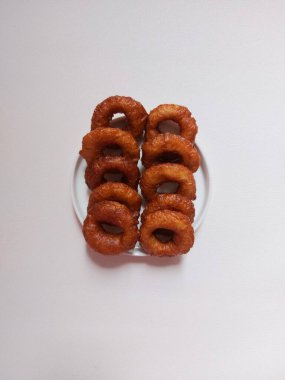 Yüzüklü pasta ya da Kue ali kabul ya da kue cincin. Sundan ya da Endonezya geleneksel tatlıları. Zevkli. Beyaz tabakta servis edilmiş. Beyazlar içinde izole edilmiş bir arka plan. Minimalist ve estetik gıda fotoğrafçılığı.