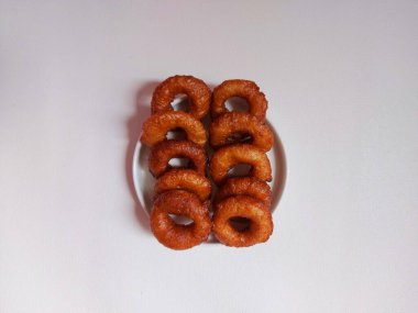 Yüzüklü pasta ya da Kue ali kabul ya da kue cincin. Sundan ya da Endonezya geleneksel tatlıları. Zevkli. Beyaz tabakta servis edilmiş. Beyazlar içinde izole edilmiş bir arka plan. Minimalist ve estetik gıda fotoğrafçılığı.