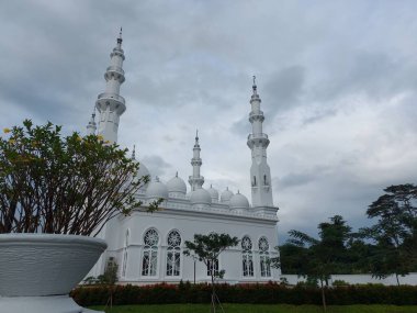 Bogor, Endonezya-Mart 12022: caminin tepesi bulanık. Masjid at-Thohir, Endonezya 'nın Bogor, West Java bölgesindeki Podomoro Golf View bölgesinde bulunan muhteşem beyaz camiinin adıdır.