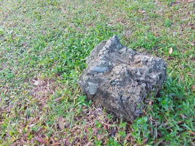 Yeşil çimlerin üzerindeki çimento topakları. Yer fotografı tekniğine göre hesapla