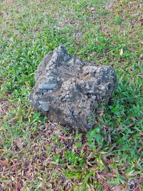 Yeşil çimlerin üzerindeki çimento topakları. Yer fotografı tekniğine göre hesapla