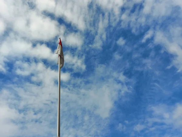 印度尼西亚国旗高高地挂在蓝天上 负空间摄影技术 版权空间 文字和引文有很大的空间 — 图库照片