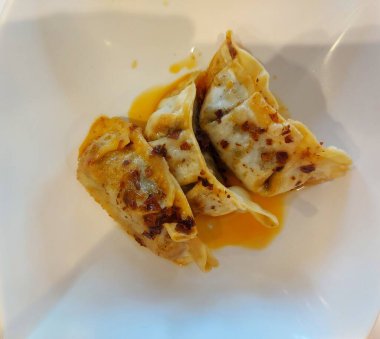 Gyoza ya da kızarmış hamur köftesi. Biber yağıyla tamamlanmış. Geleneksel Çin yemekleri