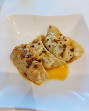 Gyoza ya da kızarmış hamur köftesi. Biber yağıyla tamamlanmış. Geleneksel Çin yemekleri