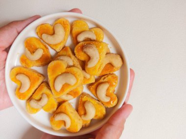 kue kering kacang mede veya kaju kurabiyesi. Tereyağından, undan, yumurtadan ve fındıklı. Beyaz tabakta servis ediliyor. Beyazlar içinde izole edilmiş sırt..