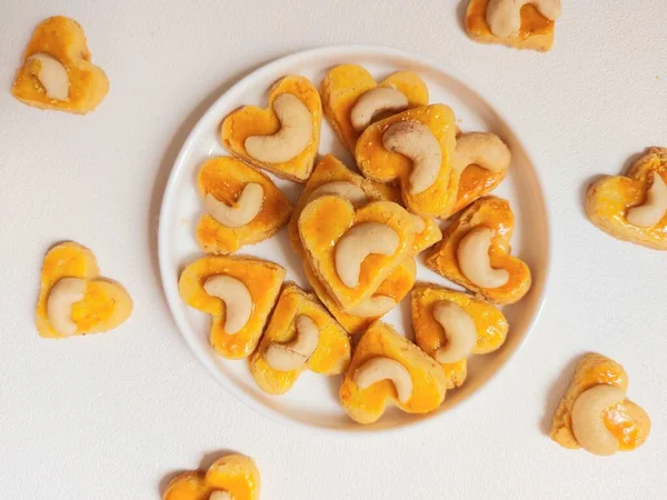 kue kering kacang mede veya kaju kurabiyesi. Tereyağından, undan, yumurtadan ve fındıklı. Beyaz tabakta servis ediliyor. Beyazlar içinde izole edilmiş sırt..