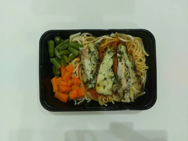 バジルペストチキンパスタ バジルペストと鶏の部分とスパゲッティボロネーゼ ニンジンと豆で — ストック写真
