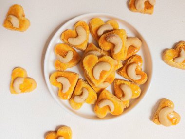 kue kering kacang mede veya kaju kurabiyesi. Tereyağından, undan, yumurtadan ve fındıklı. Beyaz tabakta servis ediliyor. Beyazlar içinde izole edilmiş sırt..