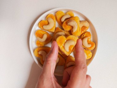 kue kering kacang mede veya kaju kurabiyesi. Tereyağından, undan, yumurtadan ve fındıklı. Beyaz tabakta servis ediliyor. Beyazlar içinde izole edilmiş sırt..