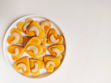 kue kering kacang mede veya kaju kurabiyesi. Tereyağından, undan, yumurtadan ve fındıklı. Beyaz tabakta servis ediliyor. Beyazlar içinde izole edilmiş sırt..