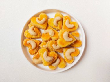 kue kering kacang mede veya kaju kurabiyesi. Tereyağından, undan, yumurtadan ve fındıklı. Beyaz tabakta servis ediliyor. Beyazlar içinde izole edilmiş sırt..