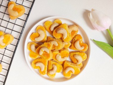 kue kering kacang mede veya kaju kurabiyesi. Tereyağından, undan, yumurtadan ve fındıklı. Beyaz tabakta servis ediliyor. Beyazlar içinde izole edilmiş sırt..