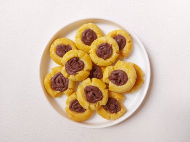 Çikolata parmak izi kurabiyeleri. Un, yumurta, tereyağı ve çikolatadan yapılmış. Beyaz tabakta servis ediliyor. izole edilmiş arkaplan. 