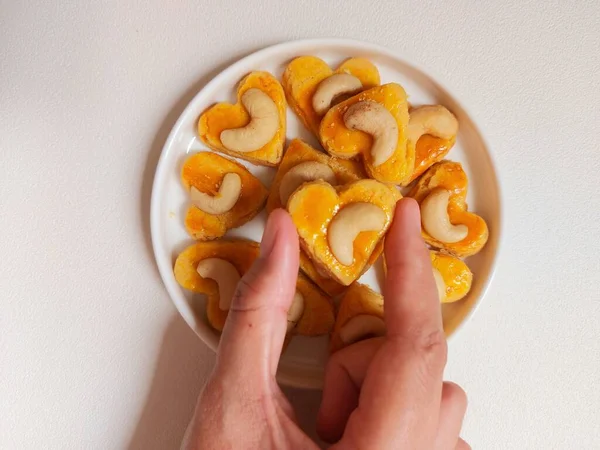 kue kering kacang mede veya kaju kurabiyesi. Tereyağından, undan, yumurtadan ve fındıklı. Beyaz tabakta servis ediliyor. Beyazlar içinde izole edilmiş sırt..