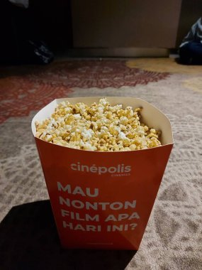 depok, indonesia-may 9 2022: pop corn on paper box. movie time concept