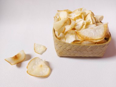 Keripik singkong goreng veya kızarmış cassava cipsi. Geleneksel Endonezya atıştırmalığı. Lezzetli bir tat. Bambu dokuma desenli seramik üzerinde servis edilir. izole edilmiş arka plan beyaz. kopyalama alanı.