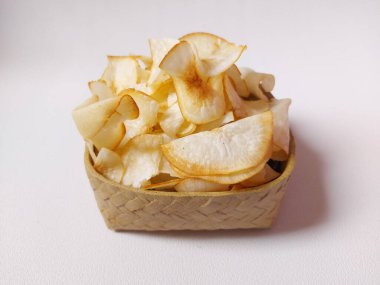 Keripik singkong goreng veya kızarmış cassava cipsi. Geleneksel Endonezya atıştırmalığı. Lezzetli bir tat. Bambu dokuma desenli seramik üzerinde servis edilir. izole edilmiş arka plan beyaz. kopyalama alanı.