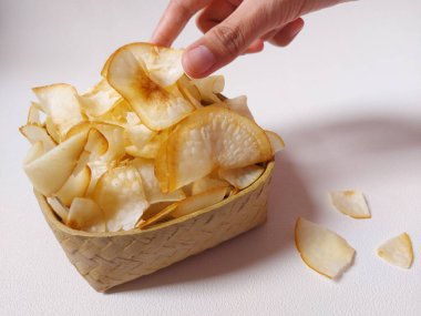 Keripik singkong goreng veya kızarmış cassava cipsi. Geleneksel Endonezya atıştırmalığı. Lezzetli bir tat. Bambu dokuma desenli seramik üzerinde servis edilir. izole edilmiş arka plan beyaz. kopyalama alanı.