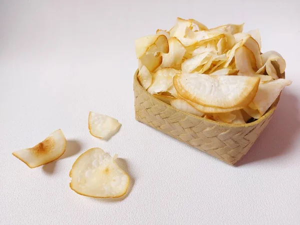 Keripik singkong goreng veya kızarmış cassava cipsi. Geleneksel Endonezya atıştırmalığı. Lezzetli bir tat. Bambu dokuma desenli seramik üzerinde servis edilir. izole edilmiş arka plan beyaz. kopyalama alanı.