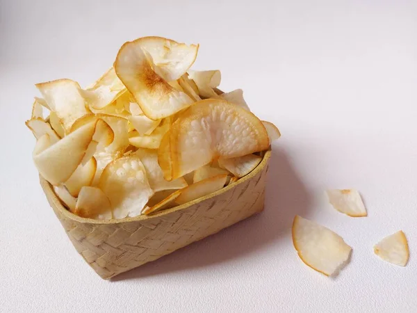 Keripik singkong goreng veya kızarmış cassava cipsi. Geleneksel Endonezya atıştırmalığı. Lezzetli bir tat. Bambu dokuma desenli seramik üzerinde servis edilir. izole edilmiş arka plan beyaz. kopyalama alanı.