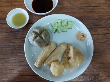 Pempek yemek takımı. Palembang, Endonezya 'dan geleneksel bir yiyecek. Un ile işlenmiş balıktan yapılır, tabakta kendine özgü sirke sosu ve tabakta kırmızı biber sosuyla servis edilir.