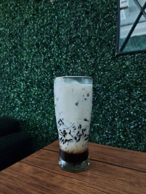 Palmiye şekerli buzlu siyah çimen jölesi ya da es susu cincau hitam gula değildir. Bardakta servis edilir. Tatlı tat. Endonezya 'dan geleneksel sağlıklı içecek.