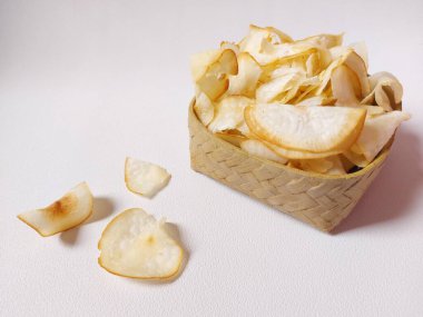 Keripik singkong goreng veya kızarmış cassava cipsi. Geleneksel Endonezya atıştırmalığı. Lezzetli bir tat. Bambu dokuma desenli seramik üzerinde servis edilir. izole edilmiş arka plan beyaz. kopyalama alanı.