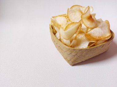 Keripik singkong goreng veya kızarmış cassava cipsi. Geleneksel Endonezya atıştırmalığı. Lezzetli bir tat. Bambu dokuma desenli seramik üzerinde servis edilir. izole edilmiş arka plan beyaz. kopyalama alanı.