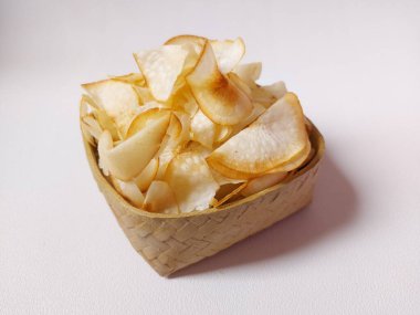 Keripik singkong goreng veya kızarmış cassava cipsi. Geleneksel Endonezya atıştırmalığı. Lezzetli bir tat. Bambu dokuma desenli seramik üzerinde servis edilir. izole edilmiş arka plan beyaz. kopyalama alanı.