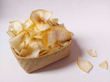 Keripik singkong goreng veya kızarmış cassava cipsi. Geleneksel Endonezya atıştırmalığı. Lezzetli bir tat. Bambu dokuma desenli seramik üzerinde servis edilir. izole edilmiş arka plan beyaz. kopyalama alanı.