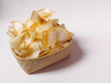 Keripik singkong goreng veya kızarmış cassava cipsi. Geleneksel Endonezya atıştırmalığı. Lezzetli bir tat. Bambu dokuma desenli seramik üzerinde servis edilir. izole edilmiş arka plan beyaz. kopyalama alanı.