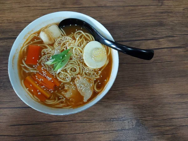 白い丼のラーメン 日本の伝統料理です おいしいですね ゆで卵 カニスティック チクワで完成 木のテーブルの上で — ストック写真