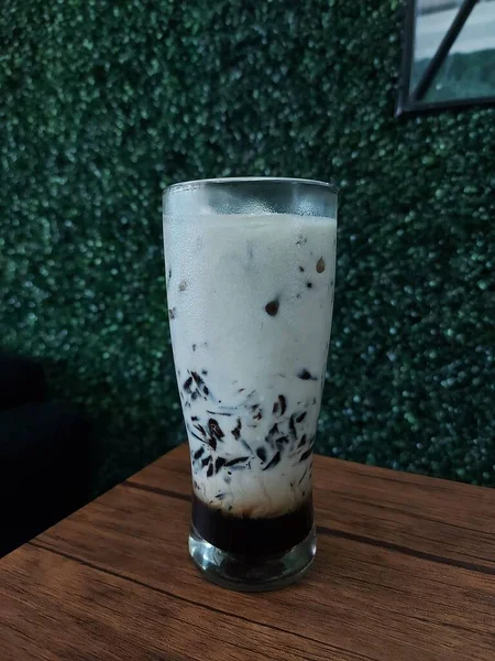ヤシの砂糖入り黒草ゼリーアイスミルクやすすすっちゅCincau Hitam Gula ガラスの上で働いてた 甘い味だ インドネシアの伝統的な健康飲料は — ストック写真