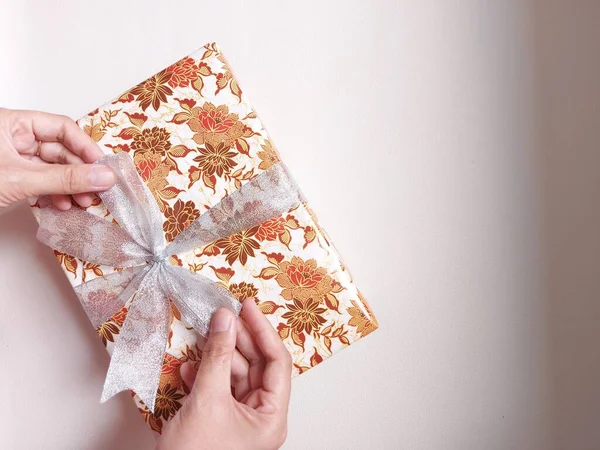 Жіночі Руки Тримають Подарункову Коробку Загорнуту Коричневий Квітковий Мотив Прикрашений — стокове фото