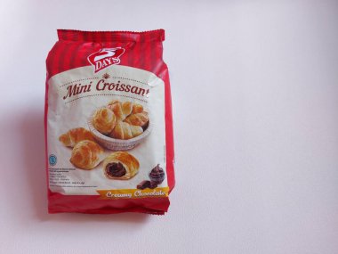 Bogor, Endonezya-Haziran 22 2022: Plastik ambalajda kremalı çikolatayla dolu mini kruvasan. 5 günlük marka. izole edilmiş arkaplan