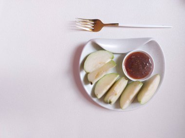 Yeşil taze kristal guava dilimlenmiş. Kahverengi şeker sosuyla tamamlanmış. izole edilmiş arkaplan