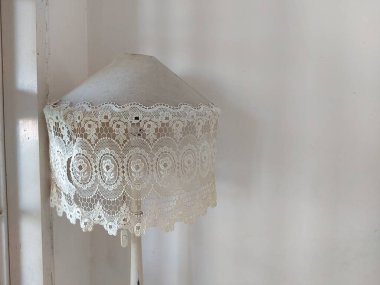 Güzel dantelli, pejmürde bir lamba. hepsi beyaz konsept. 