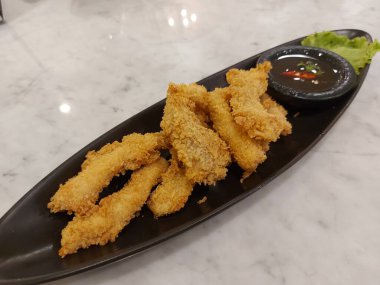Meat fritters with sauce on black plate